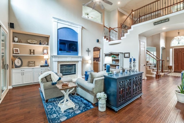 3226 Appleblossom Dr, Frisco, TX 75033 - living area with a high ceiling, arched walkways, stairway, dark wood-style floors, and a glass covered fireplace