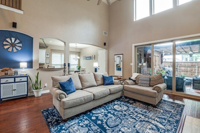 3226 Appleblossom Dr, Frisco, TX 75033 - living room with arched walkways, a towering ceiling, hardwood / wood-style floors, ceiling fan, and a chandelier