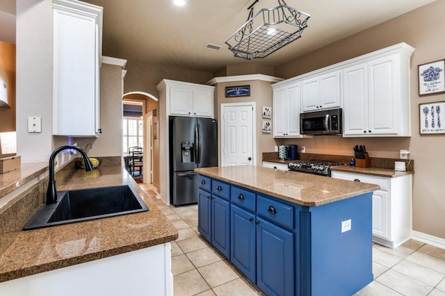3226 Appleblossom Dr, Frisco, TX 75033 - kitchen featuring black fridge, stainless steel microwave, a sink, blue cabinetry, and gas stove