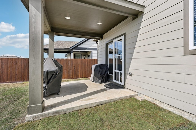 view of patio featuring a grill and fence