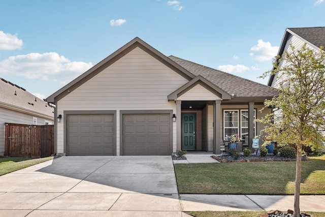 ranch-style house featuring roof with shingles, concrete driveway, fence, a garage, and a front yard