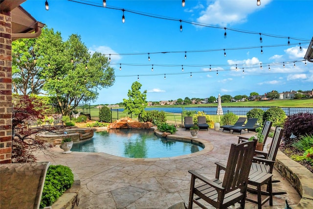 view of swimming pool featuring a patio area, a fenced backyard, a pool with connected hot tub, and a water view