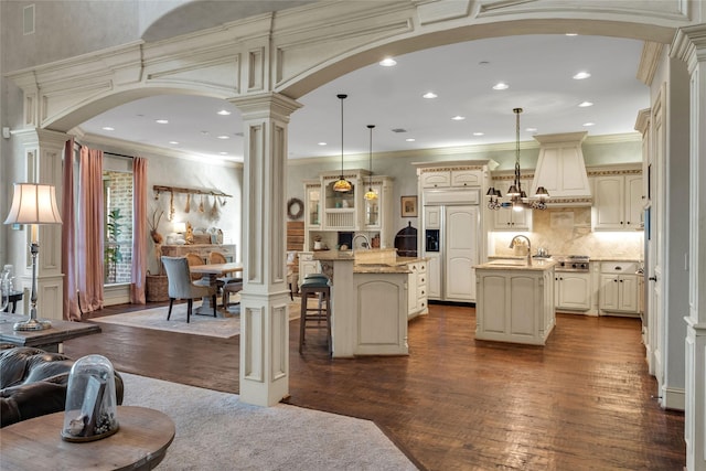 living room with recessed lighting, decorative columns, arched walkways, and dark wood-type flooring