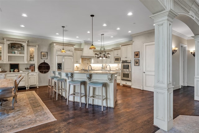 kitchen with recessed lighting, a kitchen bar, and ornate columns