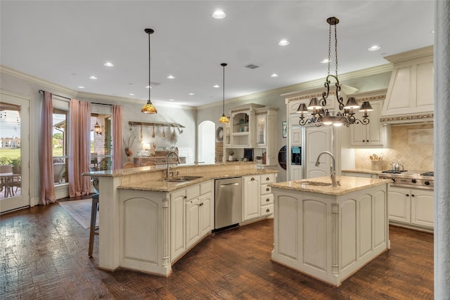 kitchen featuring ornamental molding, a kitchen island with sink, appliances with stainless steel finishes, and a sink