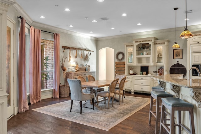 dining area featuring visible vents, arched walkways, and crown molding