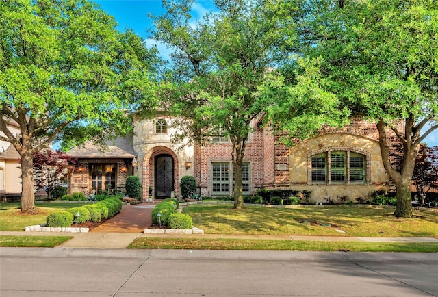 view of front of property featuring a front lawn and brick siding