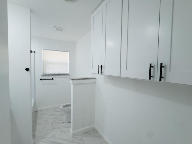 walk in closet with visible vents and marble finish floor
