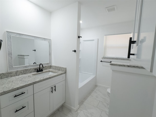 bathroom featuring toilet, vanity, marble finish floor, baseboards, and shower / bathtub combination