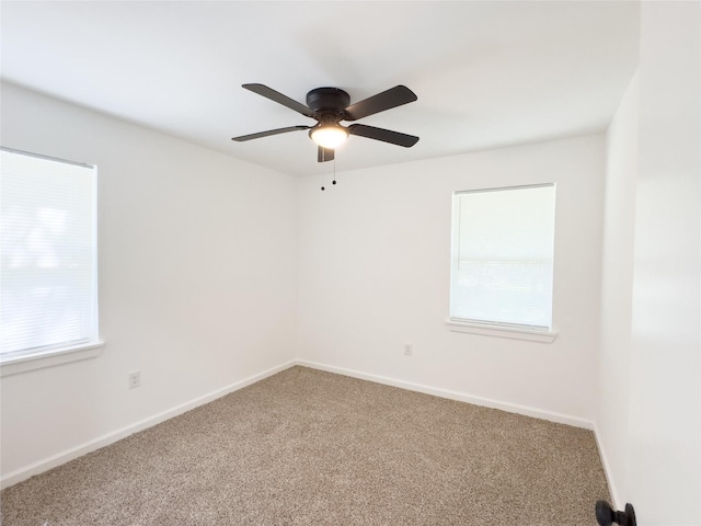 spare room with baseboards, a ceiling fan, carpet flooring, and a healthy amount of sunlight