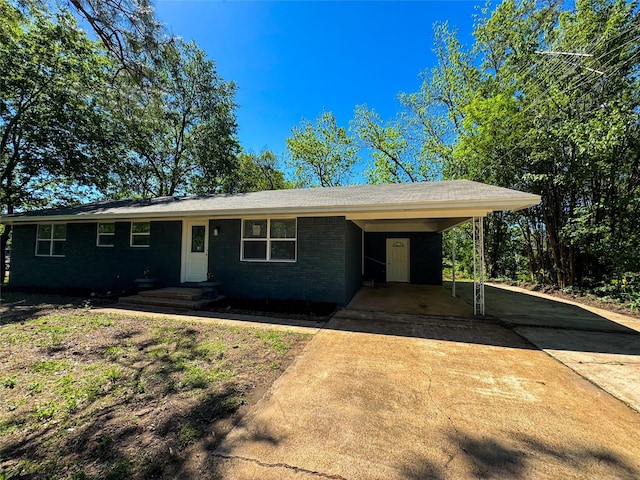 single story home with brick siding, driveway, and a carport