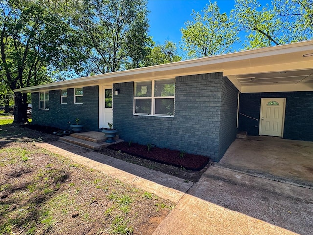 ranch-style house featuring brick siding, an attached carport, and concrete driveway