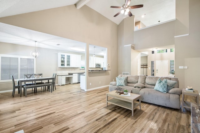 living room featuring light wood-style flooring, baseboards, beamed ceiling, ceiling fan, and high vaulted ceiling