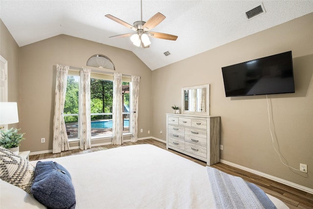 bedroom with baseboards, visible vents, lofted ceiling, wood finished floors, and ceiling fan
