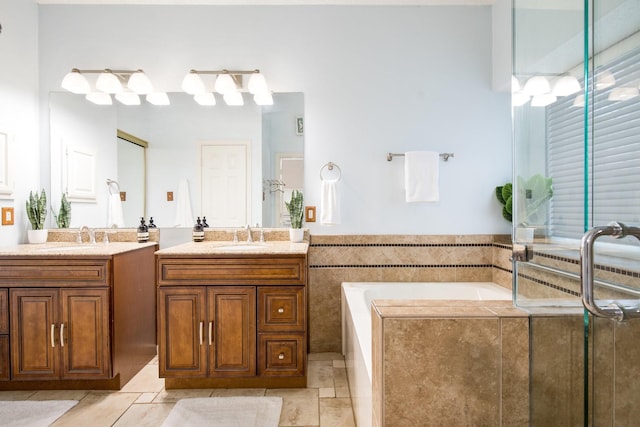 bathroom with a bath, two vanities, tile patterned floors, and a sink