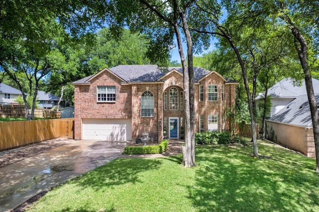split foyer home with an attached garage, driveway, brick siding, and fence