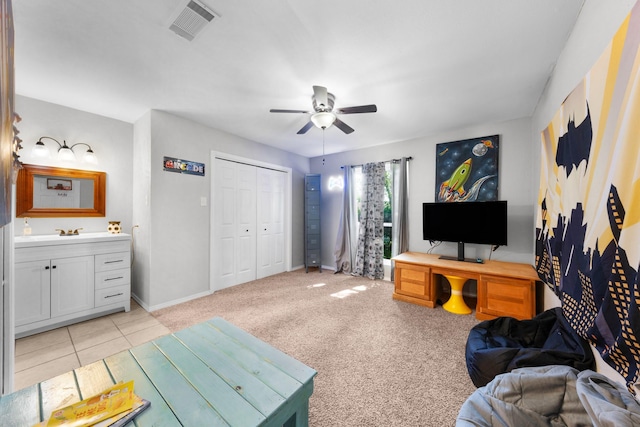 living area featuring light colored carpet, ceiling fan, baseboards, and visible vents
