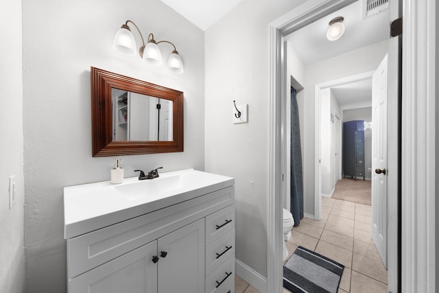 bathroom with toilet, baseboards, visible vents, tile patterned flooring, and vanity