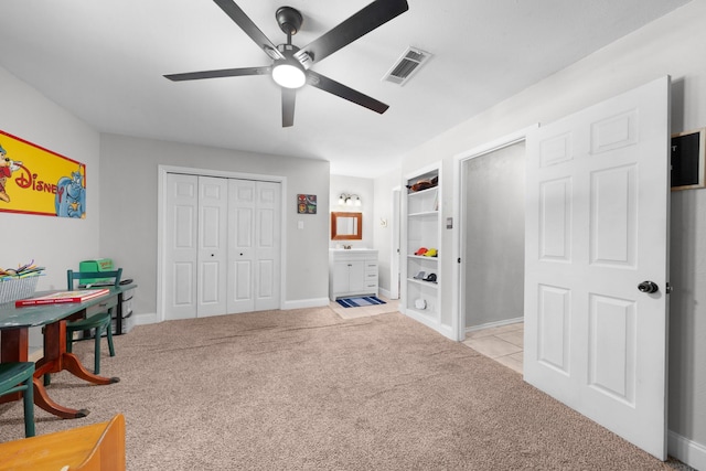 interior space featuring light carpet, a ceiling fan, visible vents, and baseboards