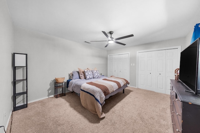 bedroom with baseboards, multiple closets, visible vents, and carpet floors