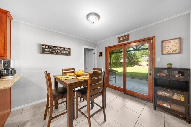 dining area featuring baseboards, ornamental molding, and light tile patterned floors