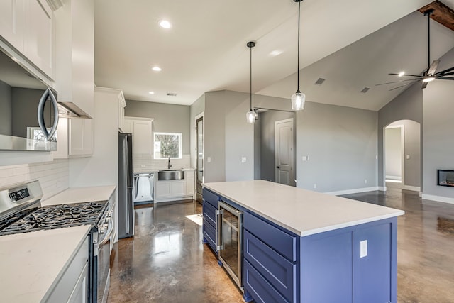 kitchen with blue cabinets, concrete floors, stainless steel appliances, and wine cooler