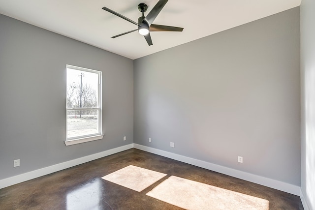 spare room with baseboards, finished concrete floors, and ceiling fan