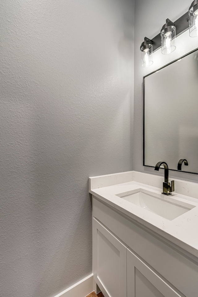 bathroom with a textured wall and vanity