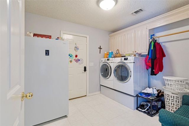259 Deer Valley Dr, Powderly, TX 75473 - clothes washing area with washing machine and dryer, a textured ceiling, visible vents, and cabinet space