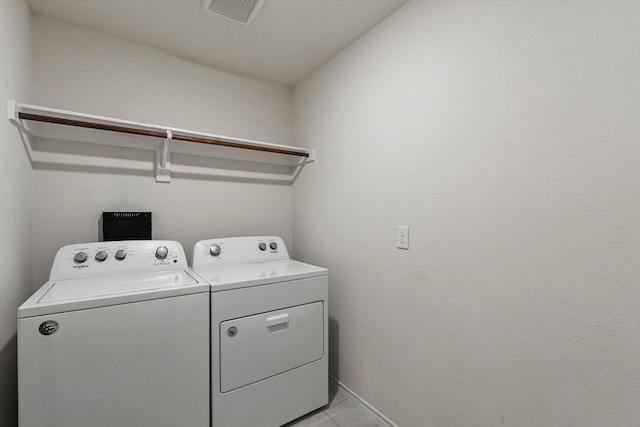 laundry room with laundry area, visible vents, light tile patterned floors, baseboards, and washer and dryer