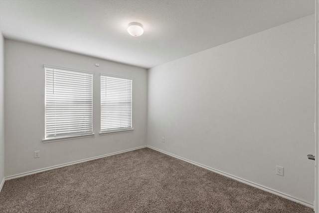 carpeted empty room with baseboards