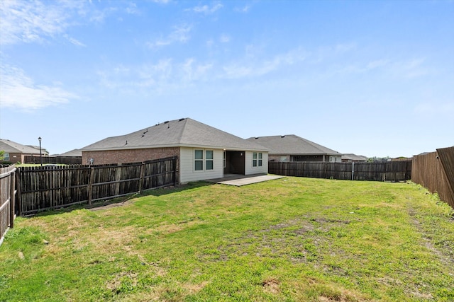 back of house featuring a patio area, a fenced backyard, and a yard