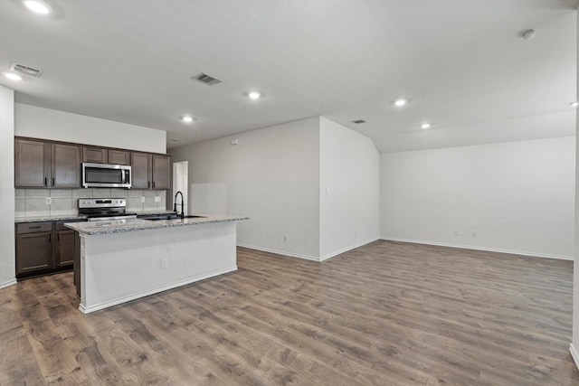 kitchen with stainless steel appliances, wood finished floors, visible vents, and a sink
