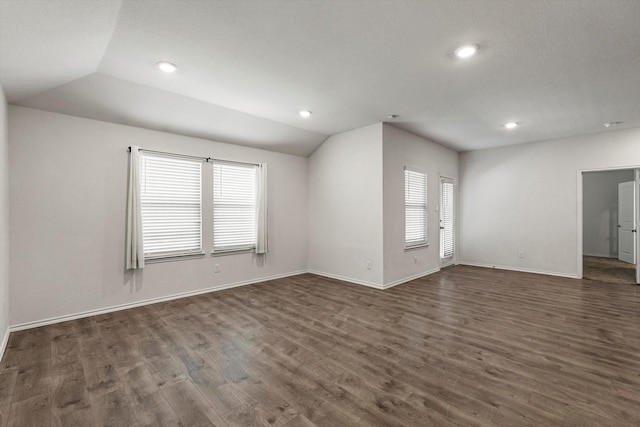 unfurnished living room with baseboards, lofted ceiling, dark wood-style flooring, and recessed lighting