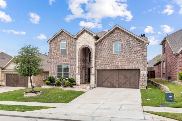 traditional-style house featuring an attached garage, driveway, brick siding, and a front yard