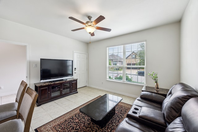 living area featuring ceiling fan, baseboards, and light tile patterned flooring