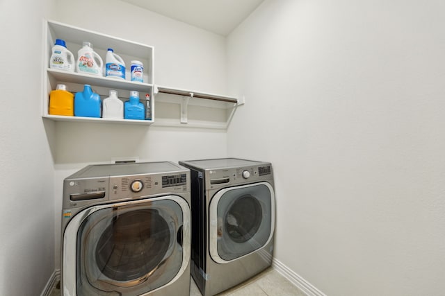 laundry area with washing machine and clothes dryer, tile patterned floors, baseboards, and laundry area