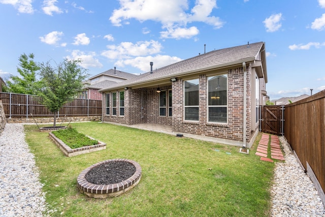 back of property featuring a fenced backyard, a gate, brick siding, a lawn, and a patio