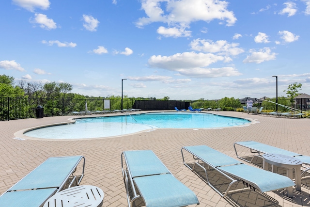 community pool featuring fence and a patio area