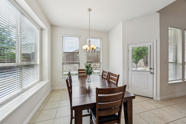 dining space with light tile patterned flooring, a chandelier, and baseboards