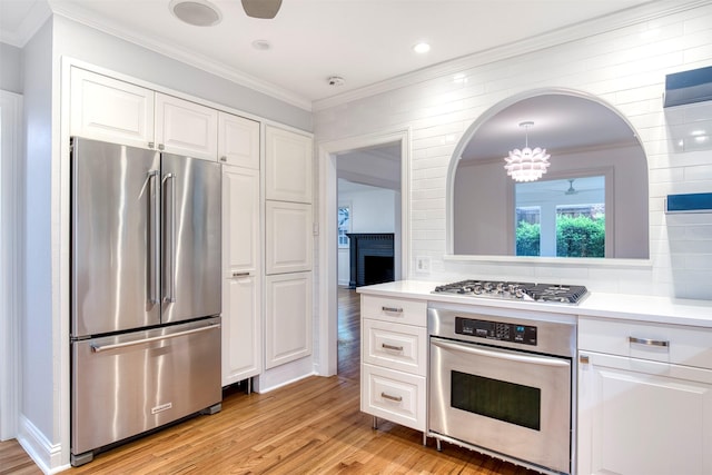 kitchen featuring light countertops, appliances with stainless steel finishes, white cabinets, and light wood-style flooring