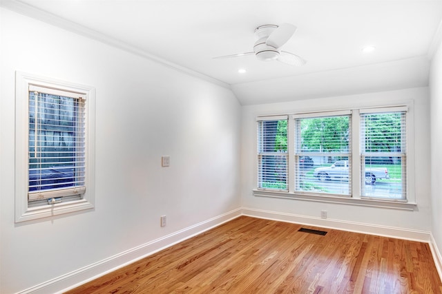 empty room with visible vents, lofted ceiling, baseboards, light wood-type flooring, and a ceiling fan