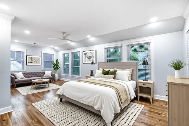 bedroom with baseboards, multiple windows, and light wood-style flooring