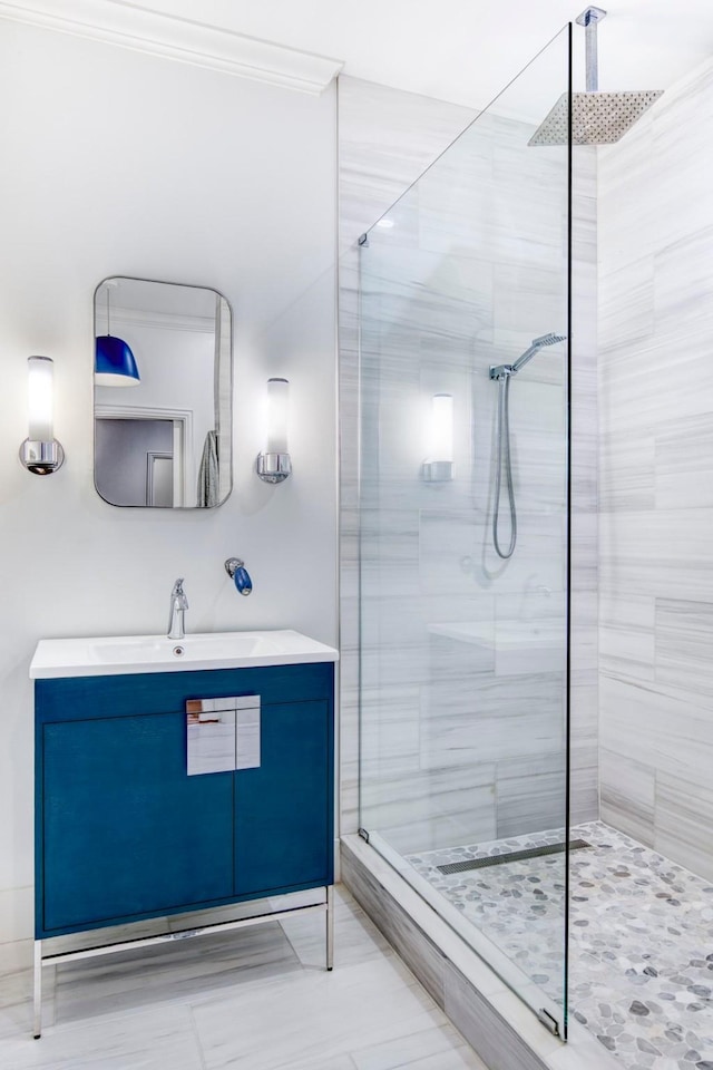 bathroom with vanity, ornamental molding, and a tile shower