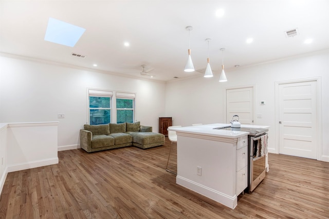 kitchen with visible vents, ornamental molding, double oven range, and light wood-style flooring