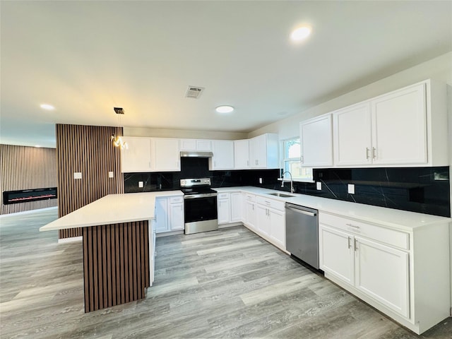 kitchen featuring white cabinets, a sink, visible vents, light wood-style floors, and appliances with stainless steel finishes