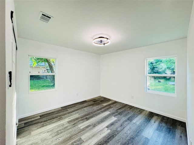 spare room with dark wood finished floors, baseboards, and visible vents