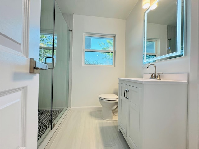 full bathroom with baseboards, a shower stall, toilet, and vanity