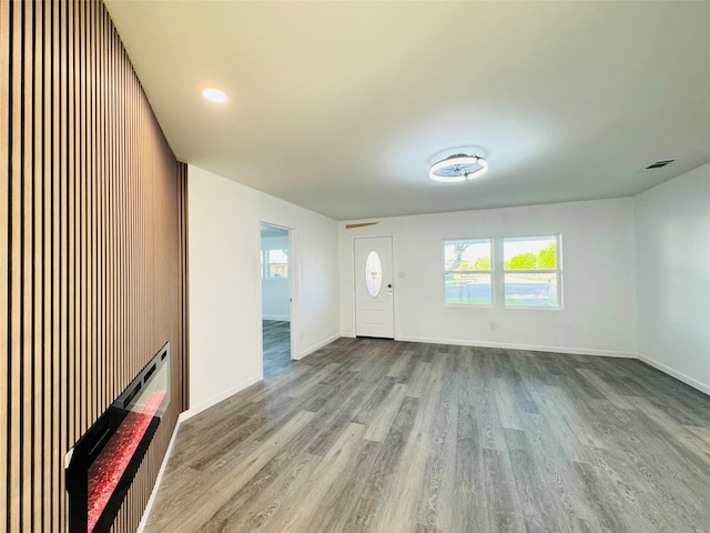 foyer with baseboards, wood finished floors, and visible vents