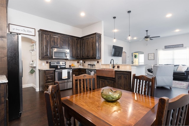 dining area with arched walkways, a ceiling fan, dark wood-style flooring, and recessed lighting